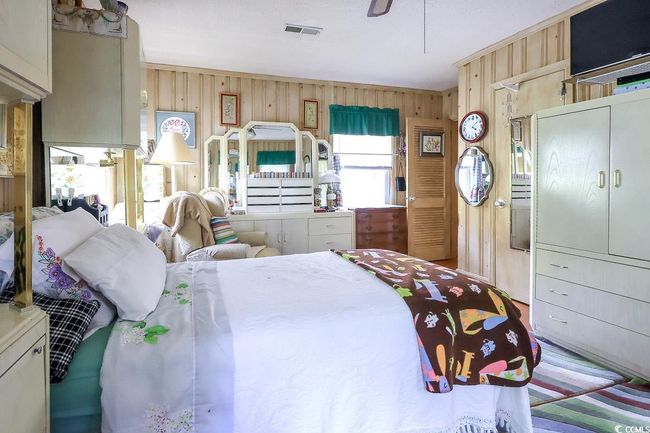 Bedroom featuring wood walls and a ceiling fan | Image 10