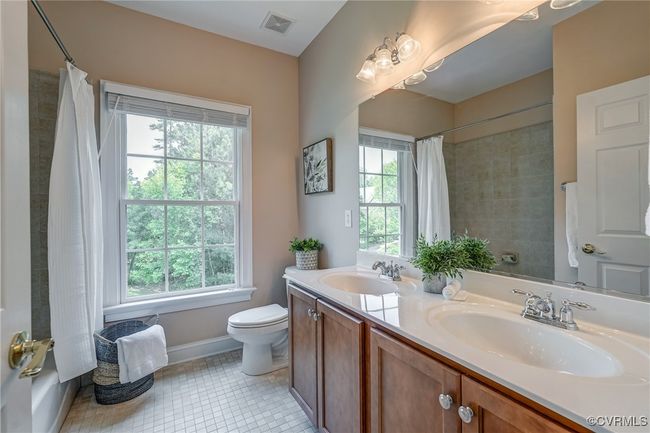 Upstairs full bath featuring a double vanity, tile floors, a soaking tub, and a tiled shower—well-appointed for style and functionality. | Image 39