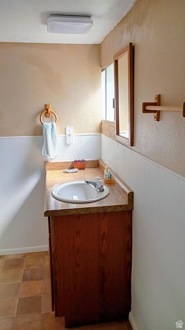 Bathroom featuring a textured wall, vanity, and a textured ceiling | Image 45
