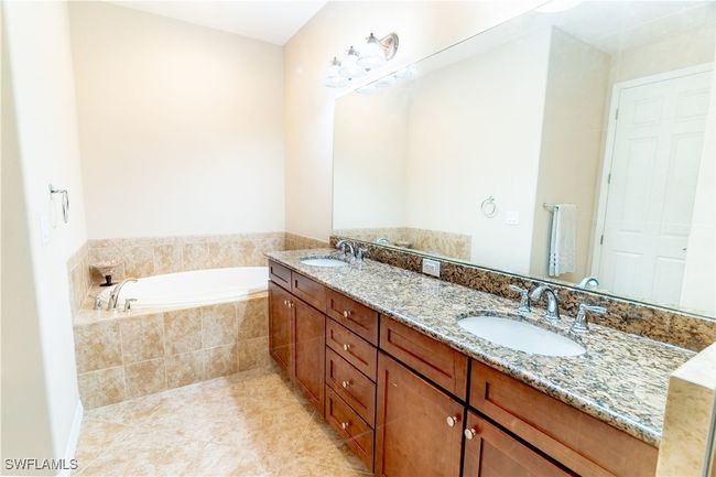 Full bathroom with a bath, double vanity, a sink, and tile patterned flooring | Image 19