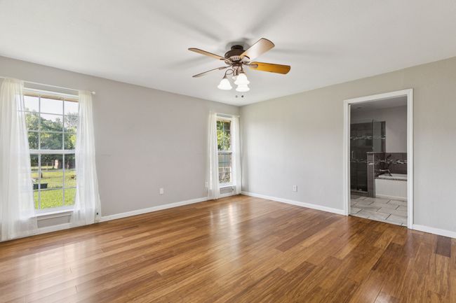 Unfurnished room with wood finished floors, plenty of natural light, and a ceiling fan | Image 10