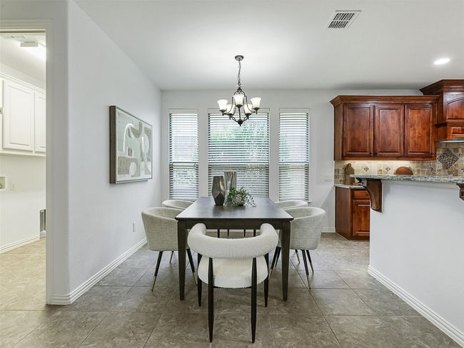 Dining area featuring a chandelier and tile patterned flooring | Image 13