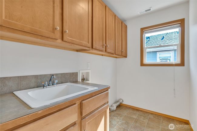 Upstaris Laundry with abundant storage cabinets and utility sink! | Image 33