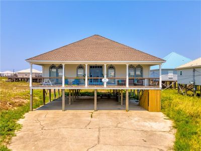 View of front of property with large covered porch. Concrete parking area. | Image 1