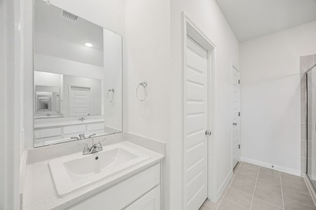 Bathroom with tiled shower, vanity, and tile patterned flooring | Image 23