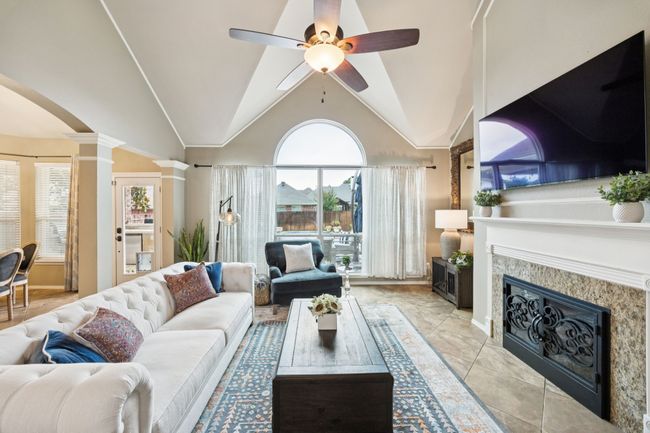 Spacious living room featuring healthy amount of natural light, ceiling fan, fireplace, and lofted ceiling with views of the beautiful pool and backyard | Image 8
