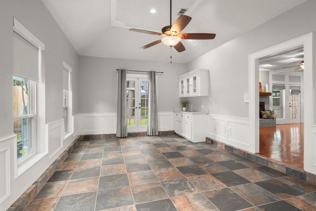 Downstairs game room is filled with natural light from wall-to-wall windows and features a stylish wet bar—perfect for entertaining. French doors open directly to the backyard, blending indoor and outdoor living. | Image 21