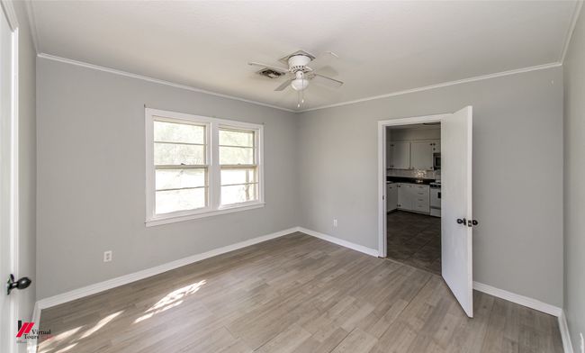 Unfurnished bedroom featuring baseboards, visible vents, crown molding, and light wood-style floors | Image 9