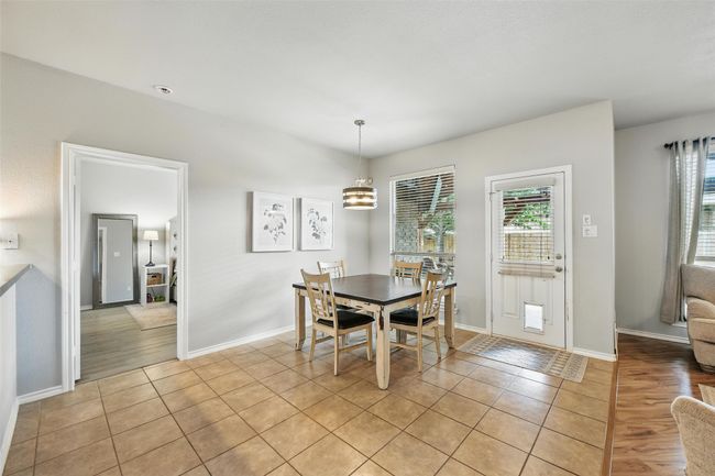 Dining room featuring light tile patterned floors and a chandelier | Image 24