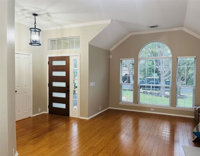 Entryway with bamboo wood flooring, a chandelier, and lofted ceiling - Plus brand new front door! | Image 4