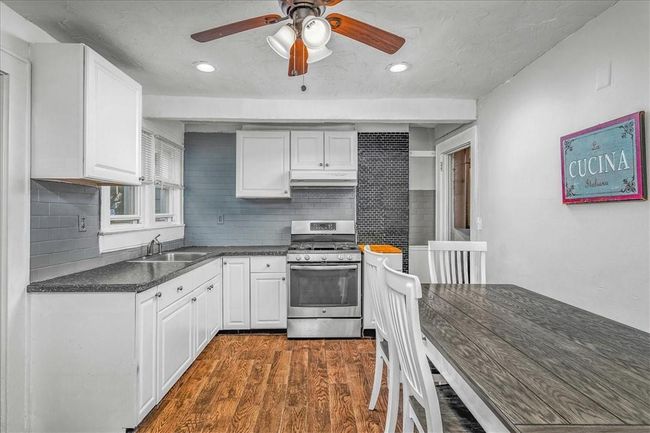 Unit # 70 Kitchen featuring decorative backsplash, dark hardwood / wood-style flooring, stainless steel gas stove, and sink | Image 27