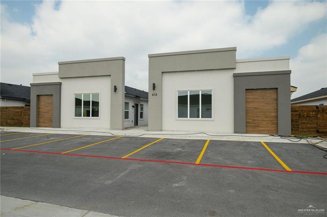 View of building exterior with uncovered parking and fence | Image 26