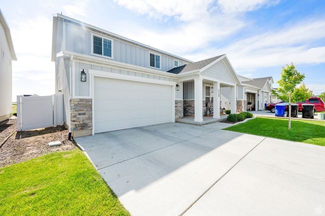 View of front of house featuring stone siding, board and batten siding, concrete driveway, and a front lawn | Image 4