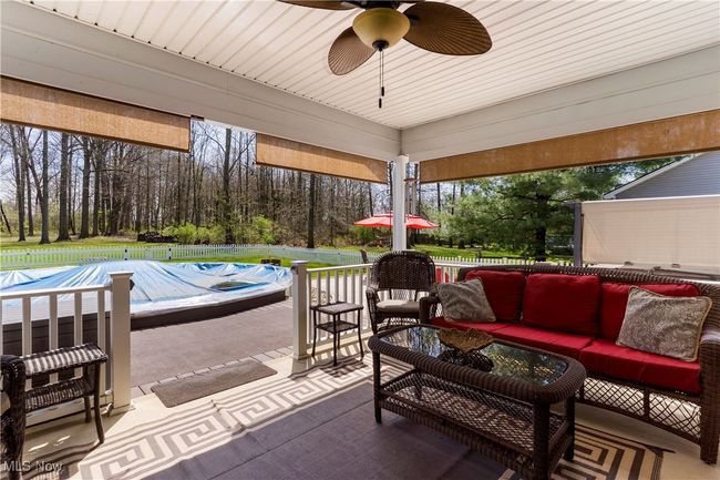 View of patio / terrace with an outdoor living space, ceiling fan, fence, and a covered pool | Image 40