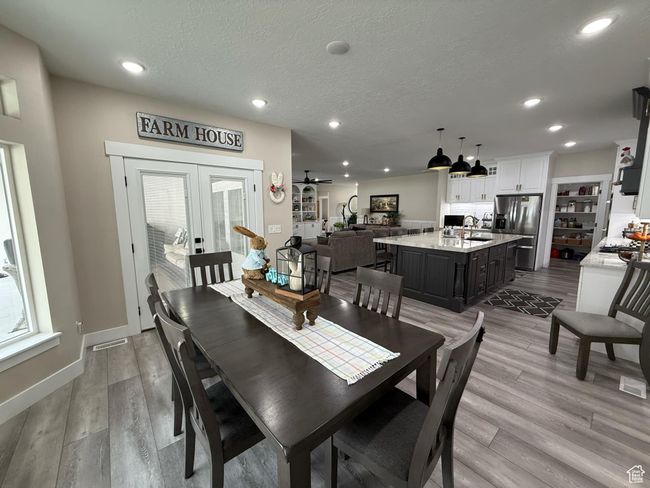 Dining room with french doors, light wood finished floors, and recessed lighting | Image 13