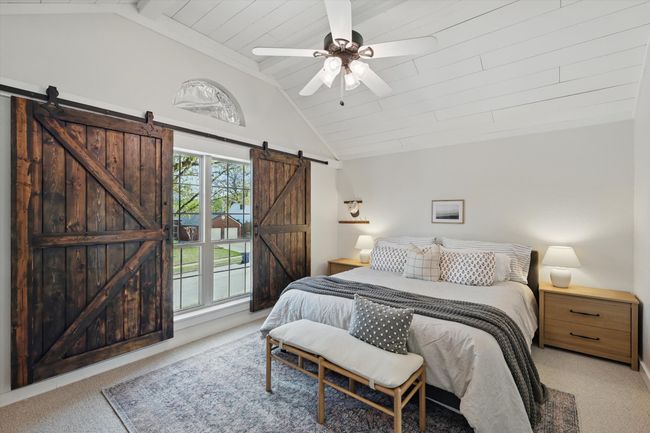 Bedroom with a barn door, carpet, ceiling fan, and wood ceiling | Image 16