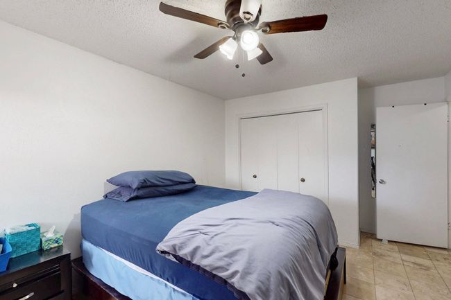 Bedroom featuring a closet, ceiling fan, and a textured ceiling | Image 23