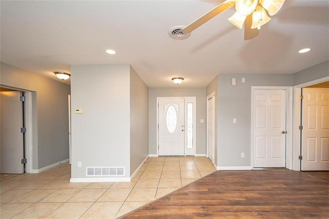 Entrance foyer featuring light tile patterned floors, visible vents, baseboards, and a ceiling fan | Image 8