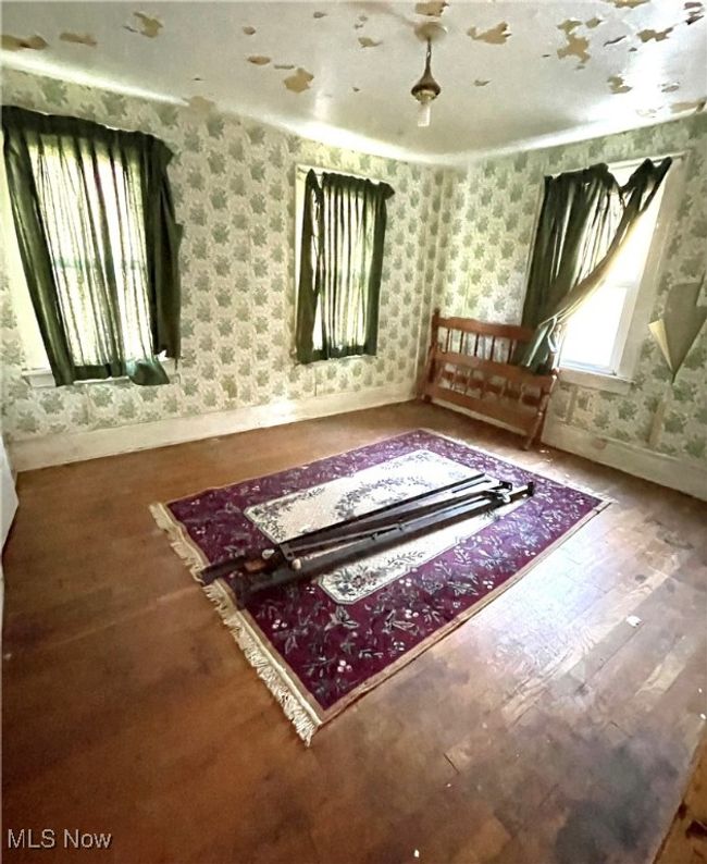 Additional living space with wood finished floors, wallpapered walls, and baseboards | Image 12