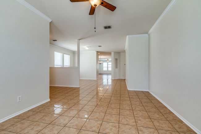 Spare room with light tile patterned flooring, ornamental molding, a ceiling fan, and visible vents | Image 12