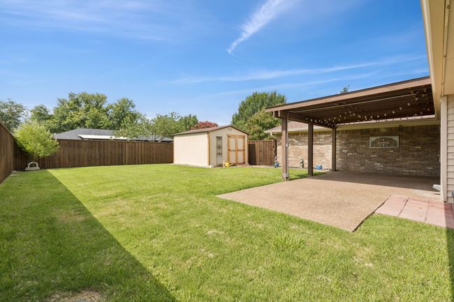 Fenced backyard featuring a shed and a patio area | Image 29