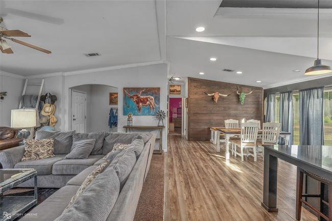 Living area featuring arched walkways, wood finished floors, ornamental molding, ceiling fan, and visible vents | Image 12