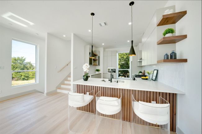 Kitchen with kitchen peninsula, extractor fan, white cabinetry, pendant lighting, and sink | Image 11