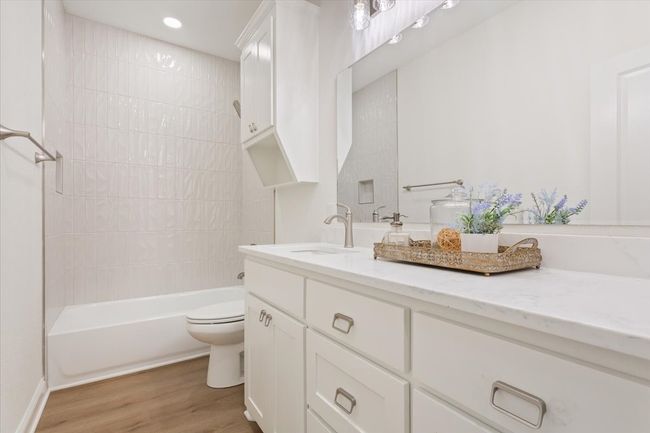 Full bath with vanity, wood finished floors, bathing tub / shower combination, and recessed lighting | Image 26