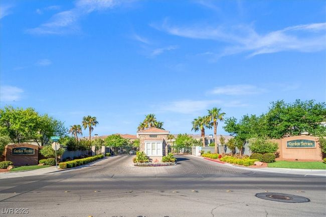 View of street with a gated entry, sidewalks, a gate, curbs, and traffic signs | Image 38