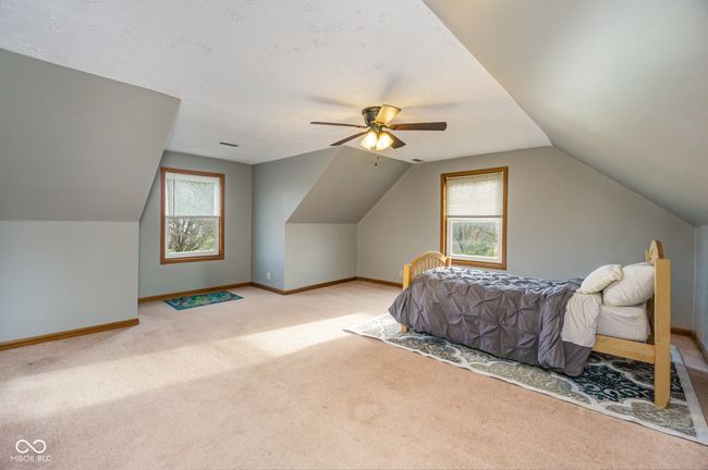 carpeted bedroom featuring baseboards, lofted ceiling, and a ceiling fan | Image 15