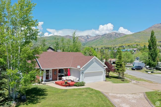 Ranch-style house with a front lawn, a mountain view, driveway, covered porch, and a garage | Image 44