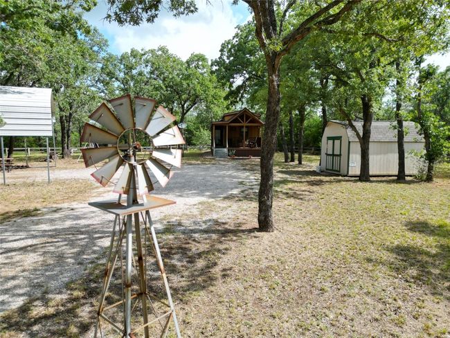 View of yard with a storage unit and view of wooded area | Image 17