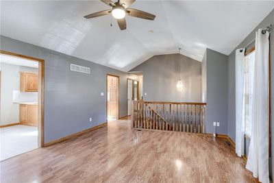 Living room with light wood-style floors, ceiling fan, and lofted ceiling | Image 3