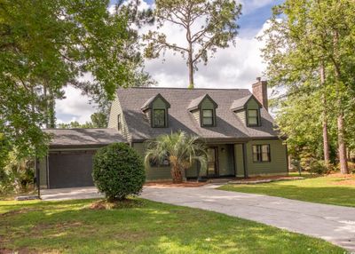 New england style home featuring a garage and a front lawn | Image 2