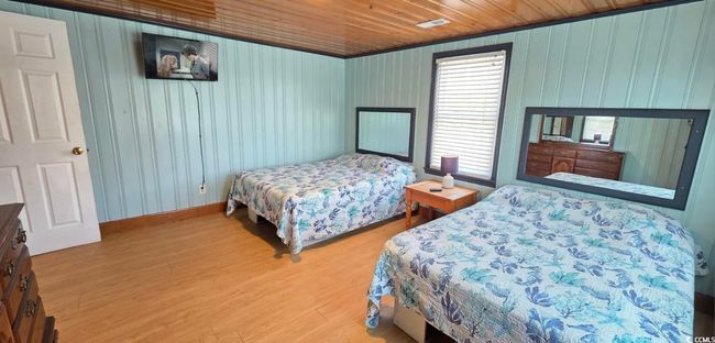 Bedroom with wood finished floors, wood ceiling, and wooden walls | Image 28