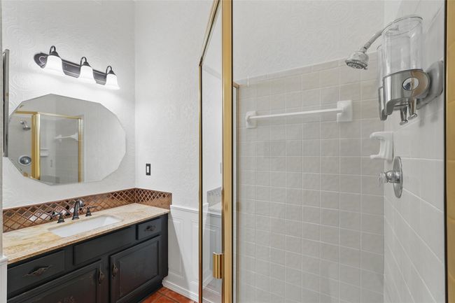 Bathroom featuring a shower stall, vanity, wainscoting, and tasteful backsplash | Image 17