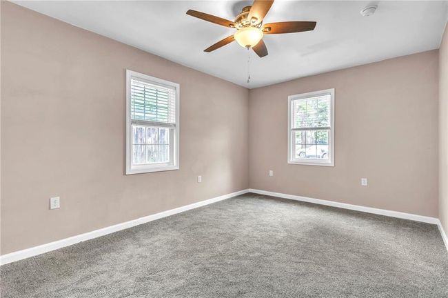 Unfurnished room featuring plenty of natural light, a ceiling fan, baseboards, and carpet floors | Image 17