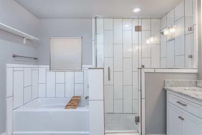 Full bath with a shower stall, a garden tub, vanity, tile walls, and recessed lighting | Image 17