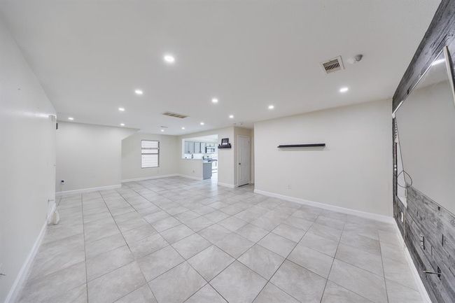 Bright tile floors enhance the living room, reflecting natural light and creating an open, airy atmosphere. | Image 13