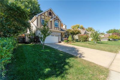 Tudor-style house featuring a front yard and a garage | Image 3