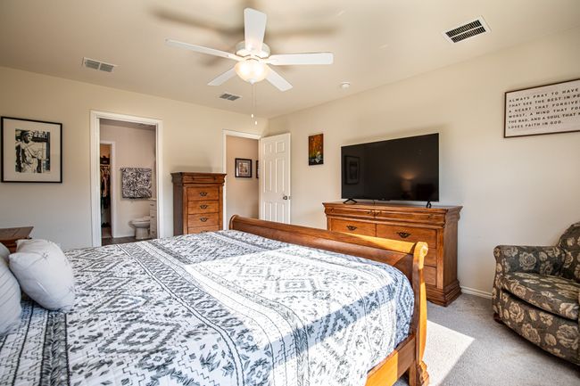 Bedroom featuring carpet flooring, ceiling fan, and ensuite bath | Image 17
