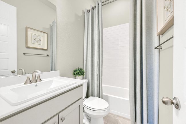 Bathroom featuring tile patterned floors, toilet, vanity, and shower / bathtub combination with curtain | Image 23