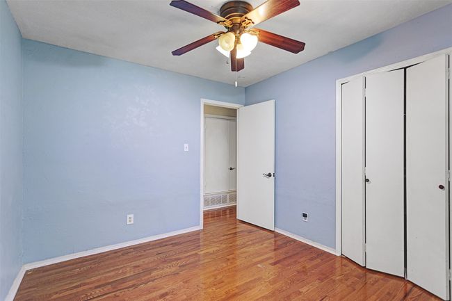 Unfurnished bedroom featuring wood finished floors, a closet, and a ceiling fan | Image 18