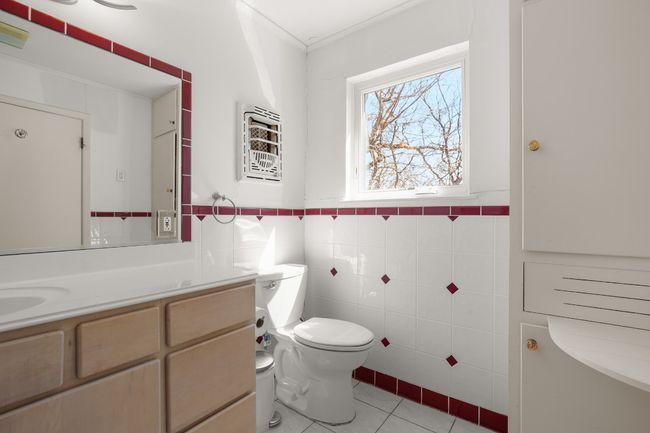 Bathroom with tile patterned flooring, toilet, vanity, tile walls, and crown molding | Image 27
