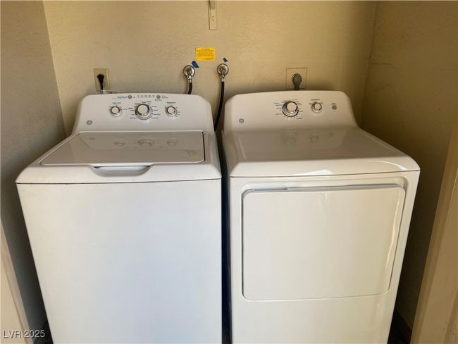 Clothes washing area featuring washing machine and dryer and a textured wall | Image 21