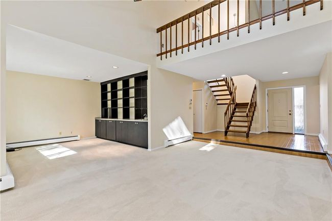 Living room/den looking to the front entry. Open balcony above with room for home office. | Image 14