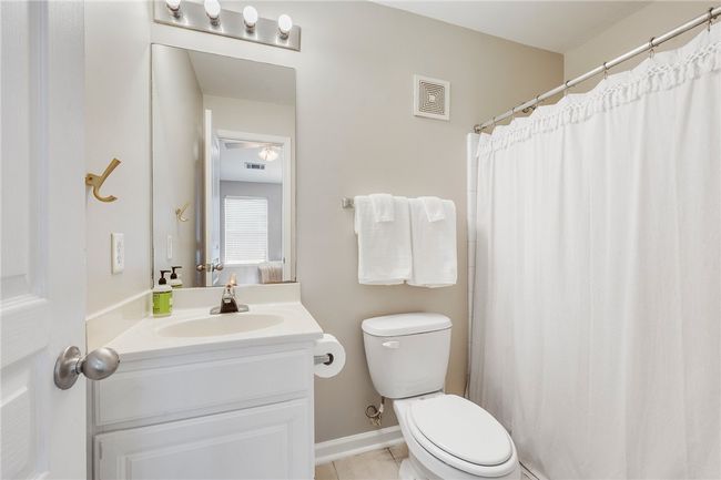 Bathroom with toilet, tile patterned floors, visible vents, and vanity | Image 14