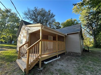 Back of house with a wooden deck and a yard | Image 1