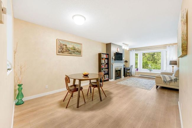 Dining room featuring a baseboard radiator, light wood-style floors, a fireplace, and baseboards | Image 26