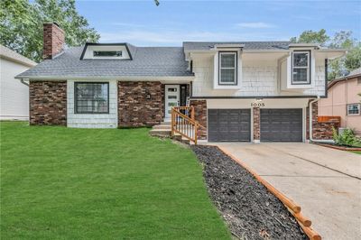 View of front facade featuring a front yard and a garage | Image 1